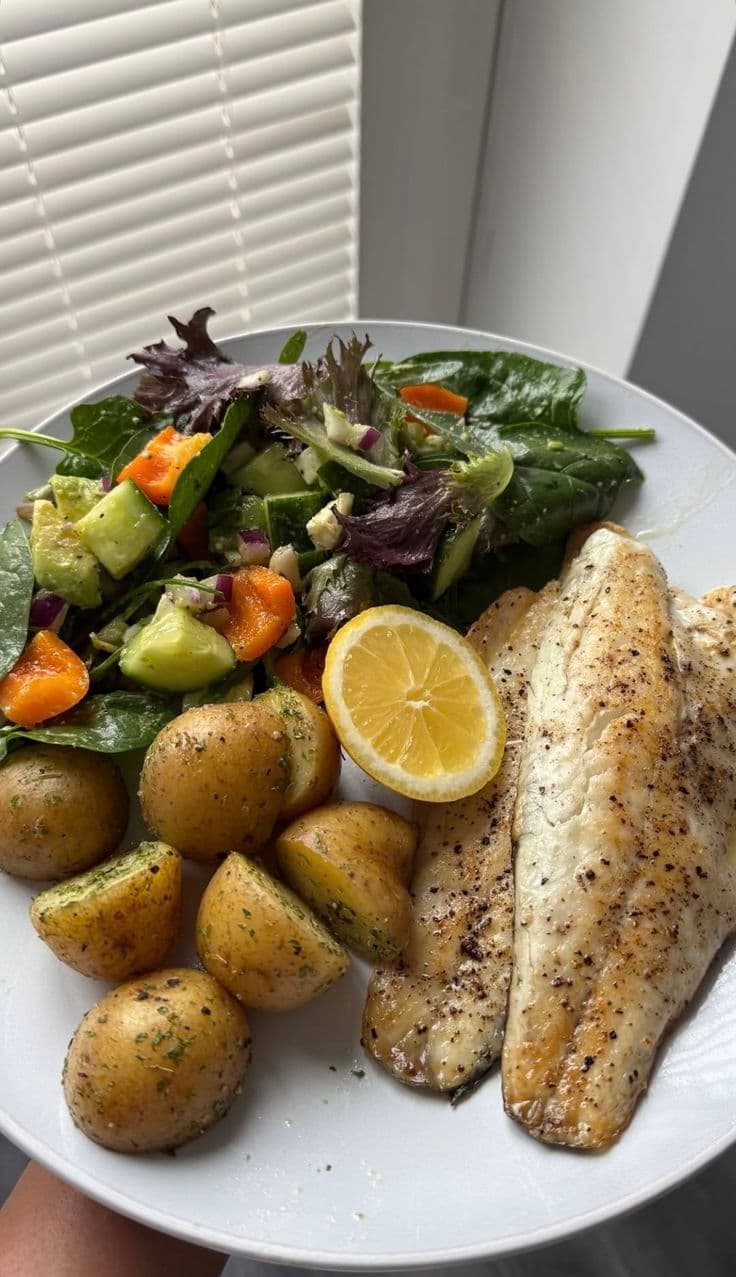 Repas maison avec poisson, pommes de terre et salade